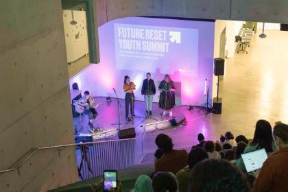 Future Reset Youth Summit Conference Hall, Three speakers are standing addressing the crowd