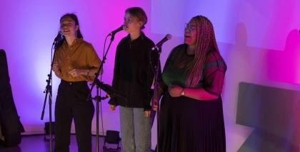 Image of three female performers singing at the Melbourne Summit