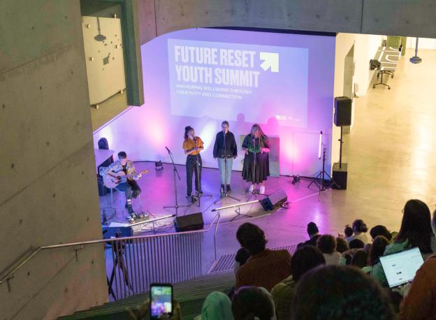 Future Reset Youth Summit Conference Hall, Three speakers are standing addressing the crowd