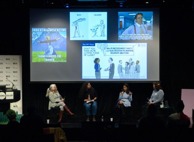 Four people sit on a panel on stage. On screen is a quote from the movie Office Space saying "yeah, if you could keep doing team leader work at entry level pay and accept the fact that you're never getting promoted, that'd be great." 