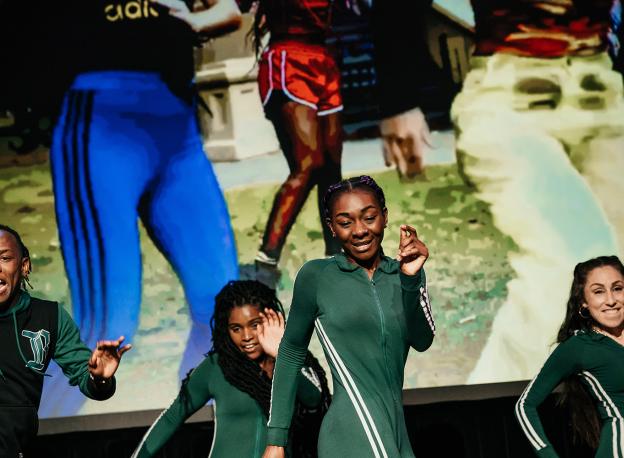 Image of people dancing/performing on stage.