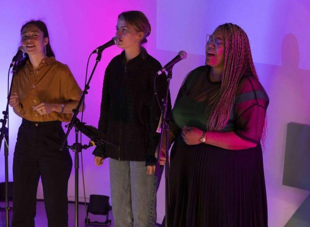 Image of three female performers singing at the Melbourne Summit