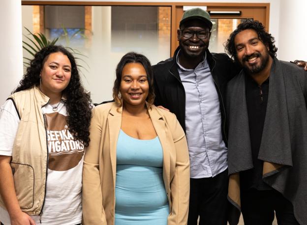 Four people standing together facing the camera and smiling. All of the people have been involved in the Mental Health Literacy Project